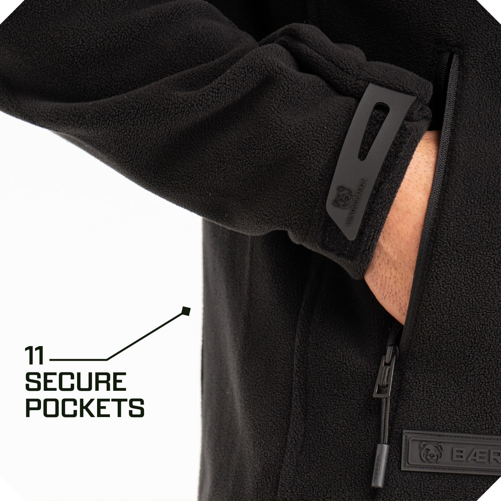 Black fleece jacket with hand in zippered side pocket, adjustable cuff tab, and text: 11 secure pockets
