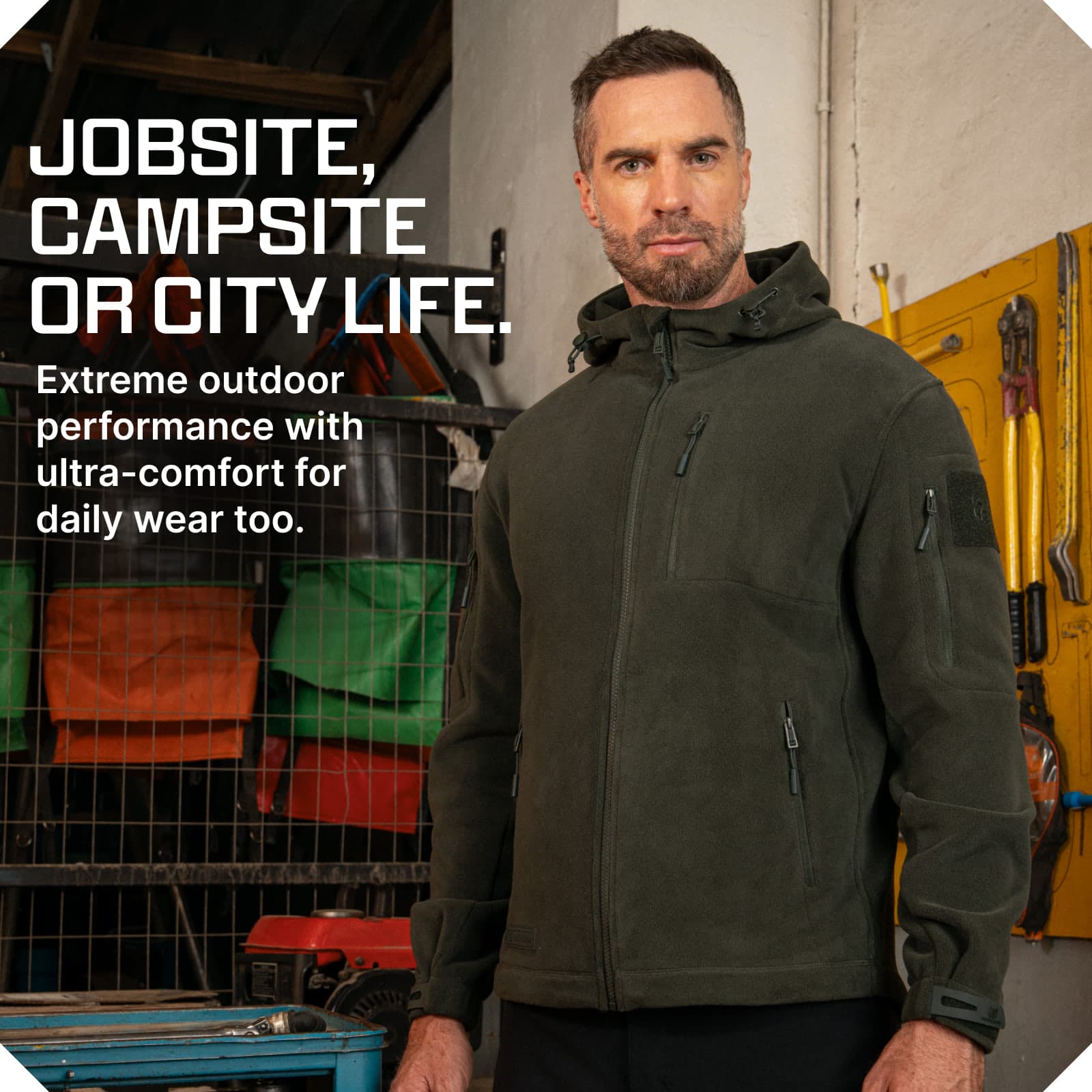 Man wearing an olive green tactical fleece hoodie with multiple zippered pockets and adjustable cuffs
